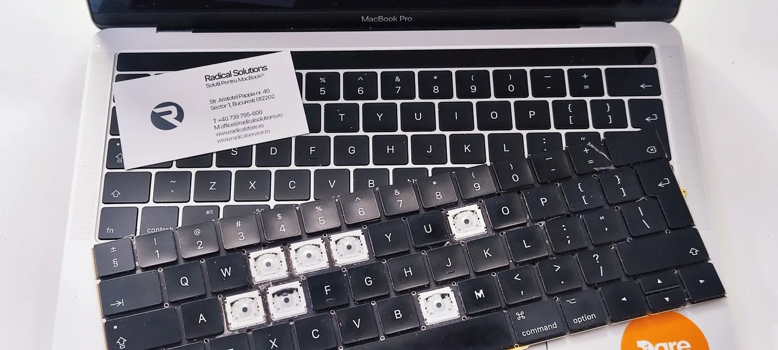 Înlocuire tastatură MacBook Pro: tastatura veche cu taste lipsă scoasă din laptop, în atelierul Radical București